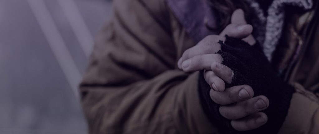 A person wrings their hands in a sepia-toned photo.