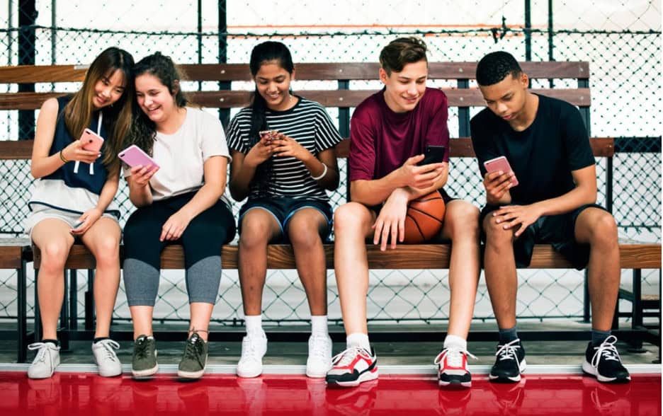 A group of students hang out on a set of bleachers.