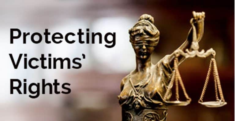 A gold justice statue stands next to text reading "Protecting Victims Rights"