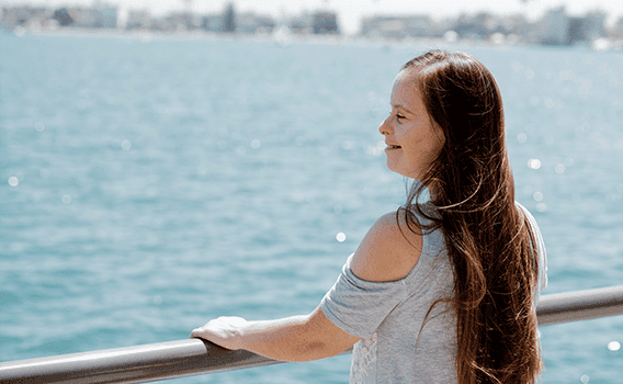 A woman with developmental disabilities looks out at the lake.