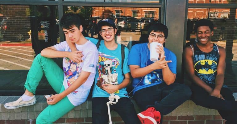 A group of 4 teen boys sitting together and smiling