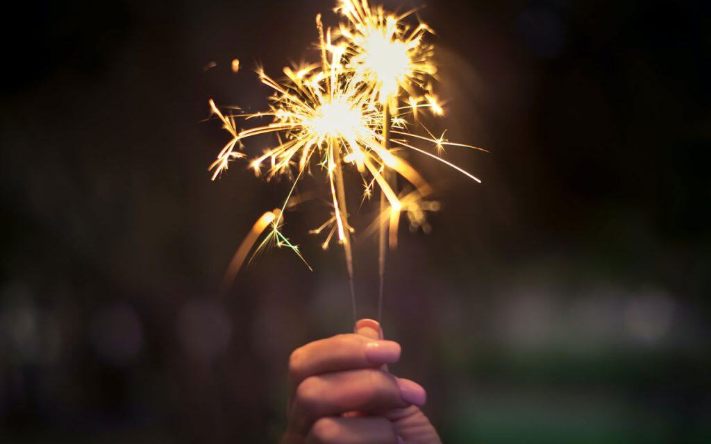 A close up of a hand holding a sparkler
