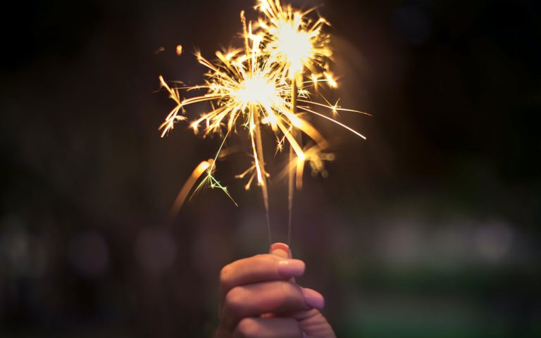 A close up of a hand holding a sparkler