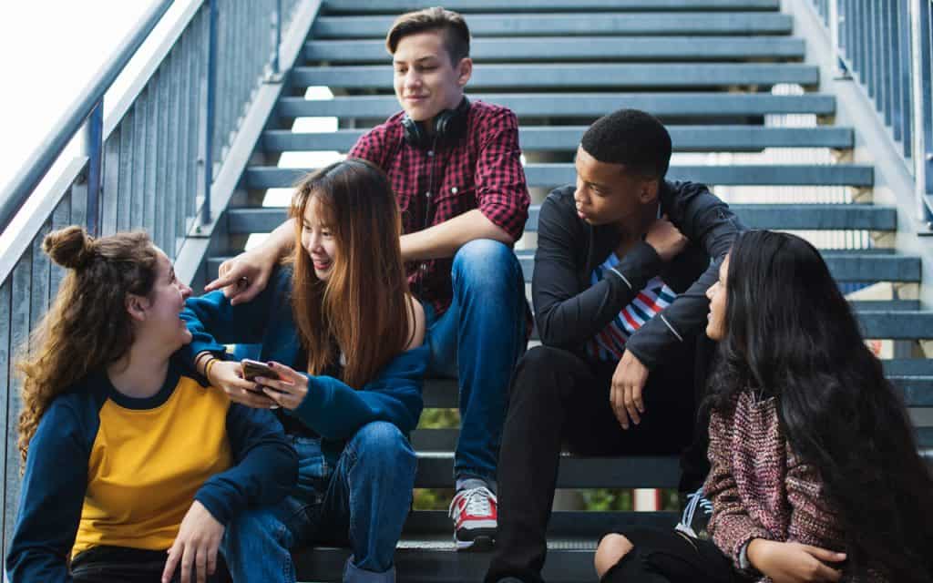 High school students sitting on steps talking