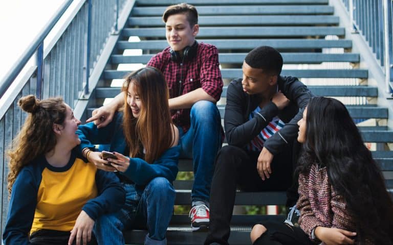 High school students sitting on steps talking