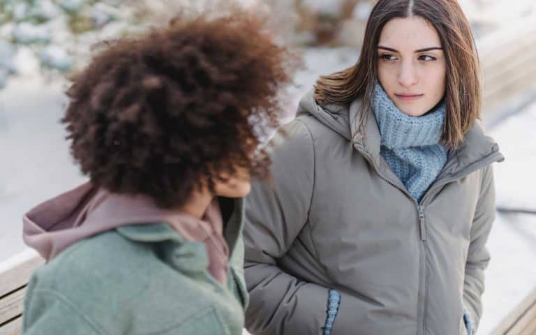 Two young women on a park bench having a serious conversation
