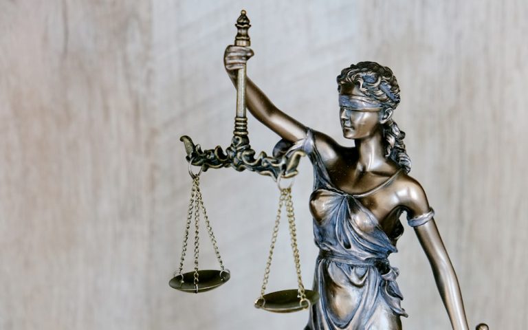 Statue of lady justice who is a blindfolded women holding scales and a sward.