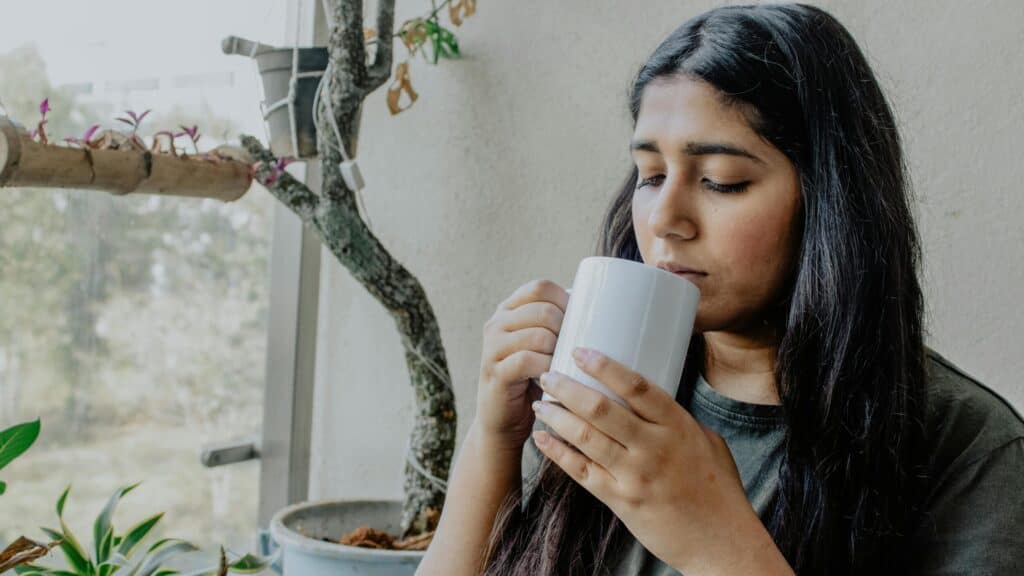 Woman sips from a mug.