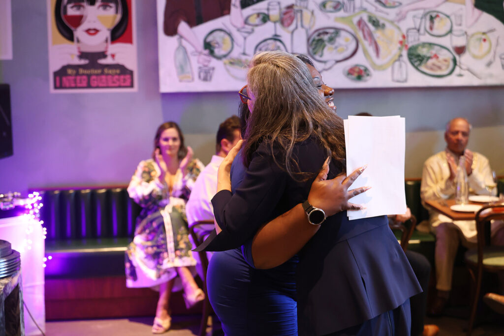 Kaethe Morris Hoffer and Saunte Harden-Tate hug.